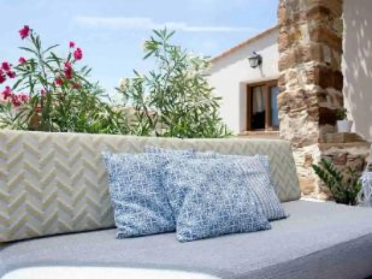 Outdoor lounge with stone walls and flowering oleanders at Voulamandis House in Kampos, Chios