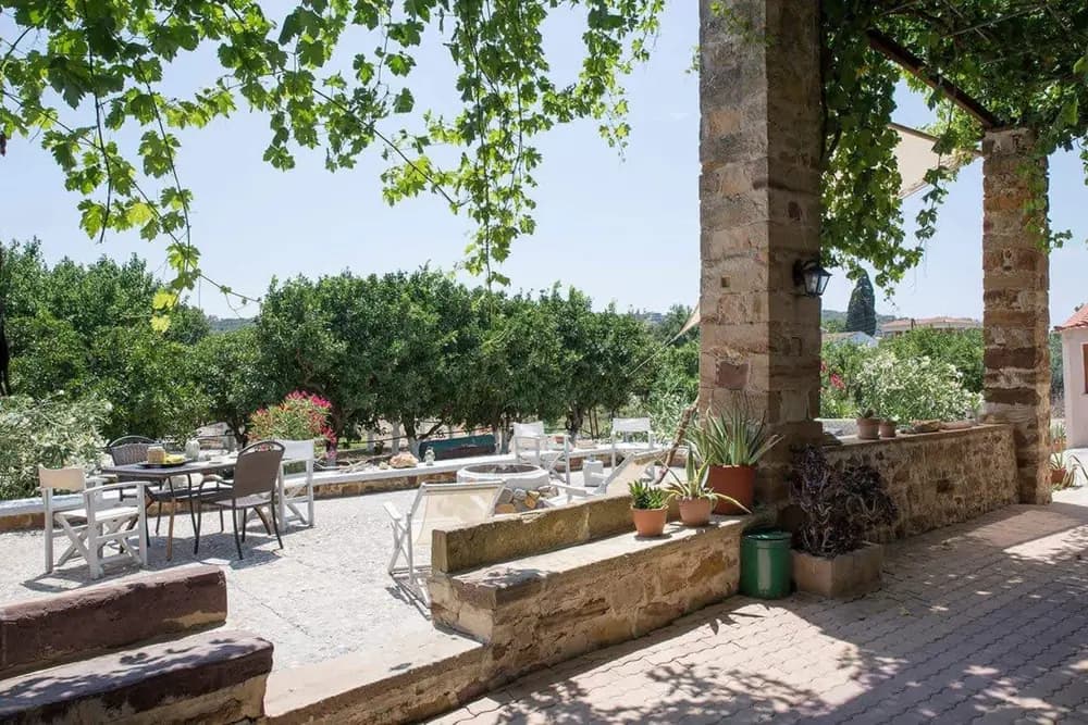 Shaded garden courtyard with tables at Voulamandis House in Kampos, Chios